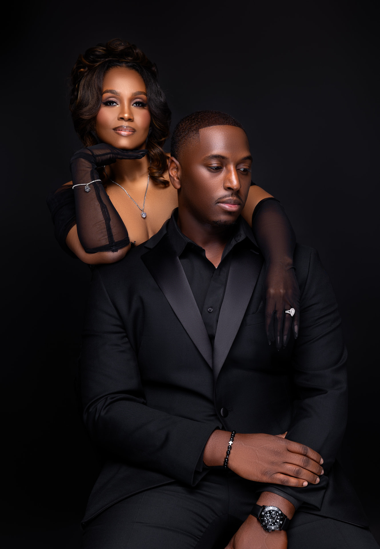 Engaged couple in an elegant black studio portrait