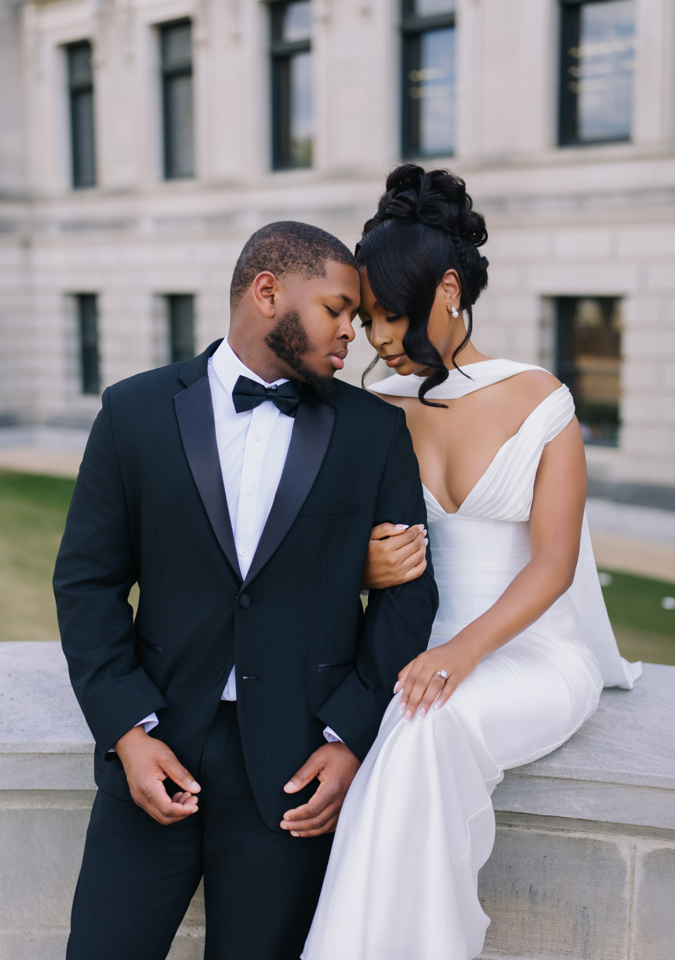 Engaged couple sharing an intimate moment beside a stone terrace