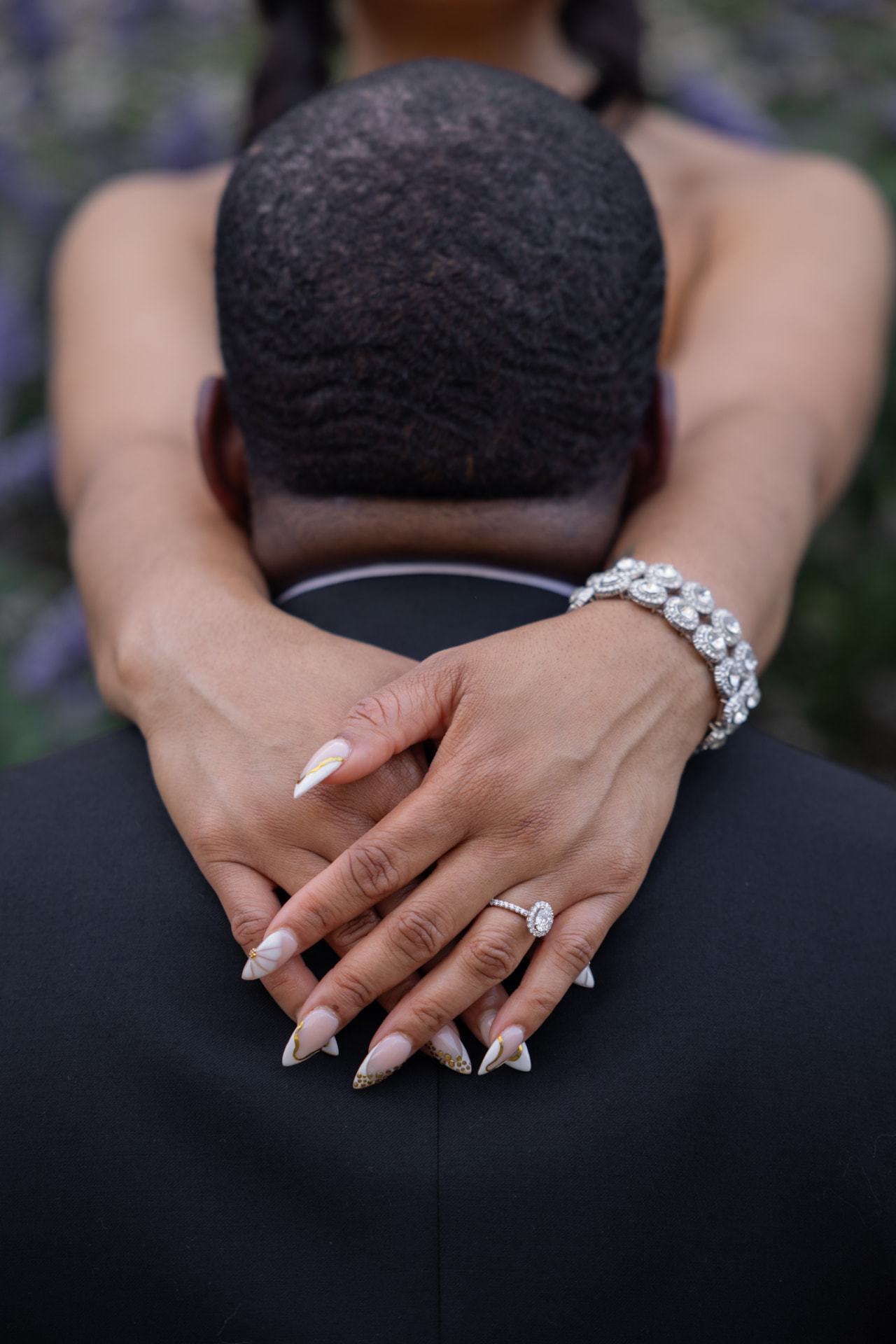 Bride-to-be showing her engagement ring while embracing her partner