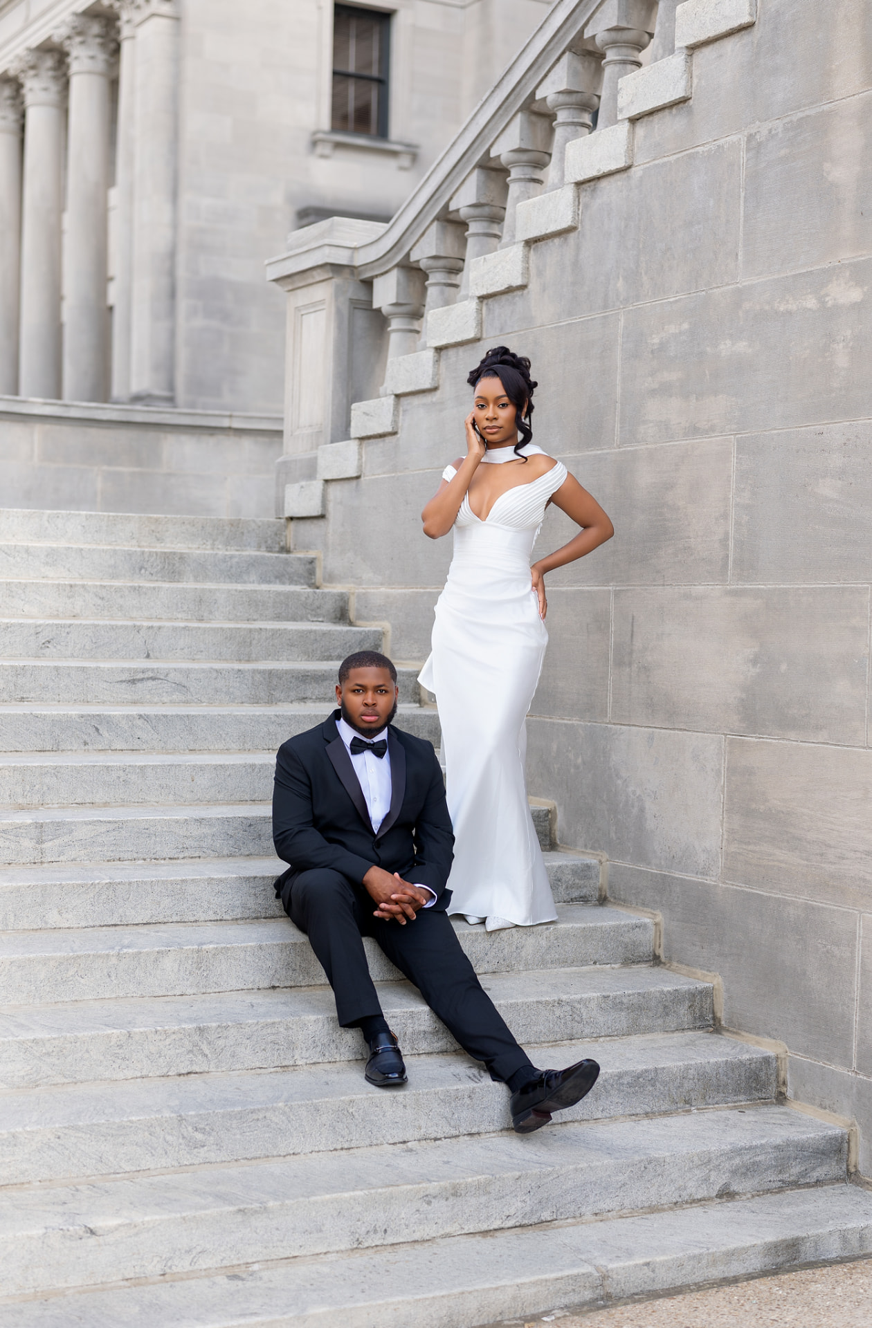 Engaged couple posed together on stone steps